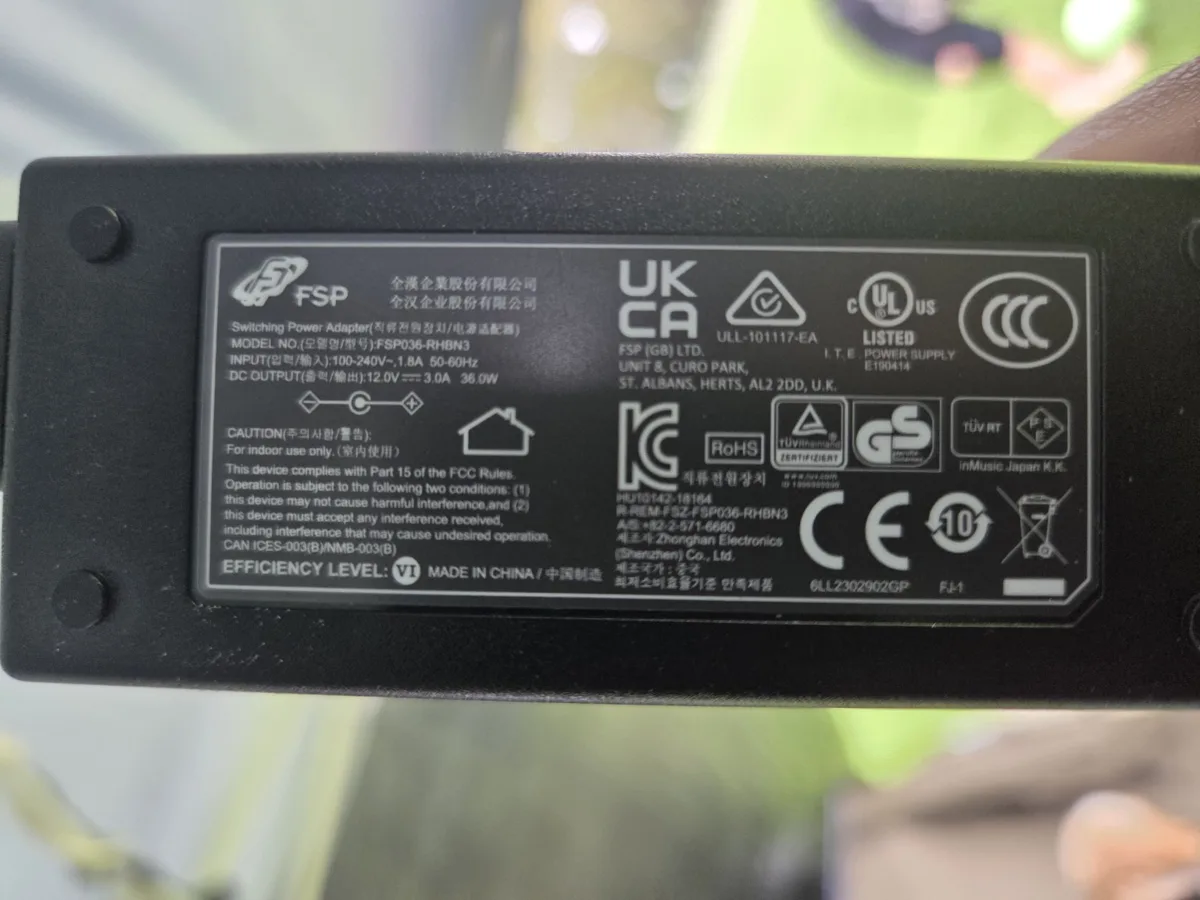 Original Denon power adaptor label showing 12V DC 3A centre-positive output